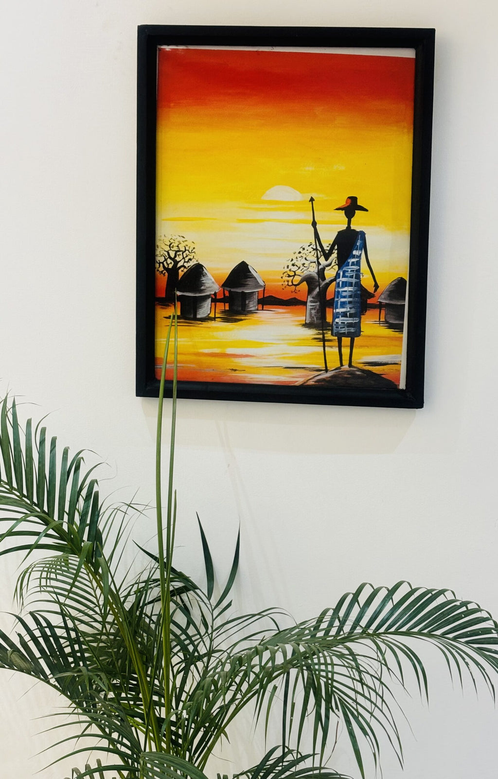 Man with Spear in Front of Huts and Sunrise