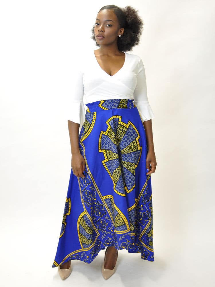 Frontal of model wearing a blue and gold African Ankara print maxi skirt with dip hem / high low design.