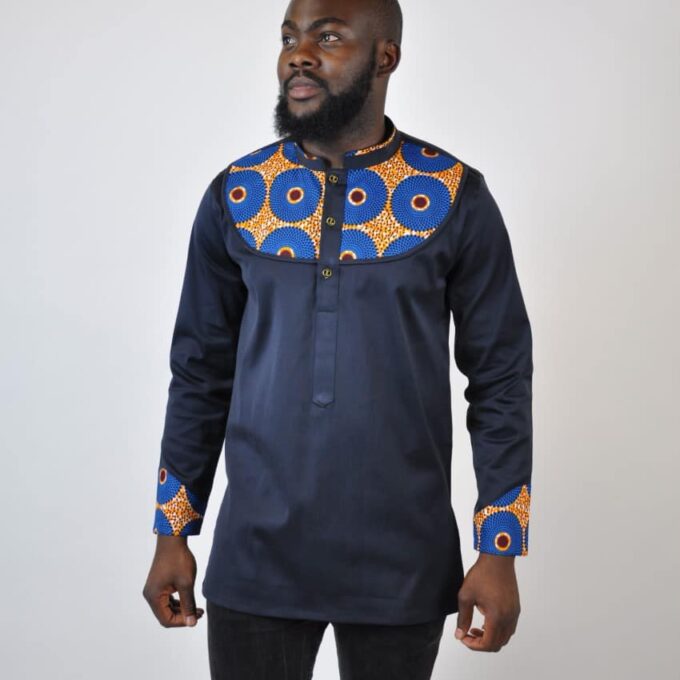 Full frontal of model wearing a men's dark blue / back shirt with stand collar and Subra African print detail on the chest, neckline and cuffs./