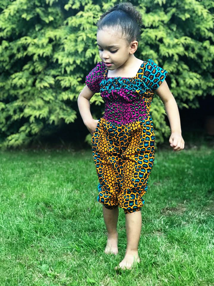 Frontal of model wearing a colourful African Ankara jumpsuit in all over animal print pattern.