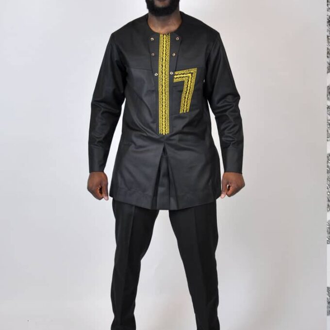Full frontal of model wearing a men's black traditional African suit with gold embroidery on the chest.