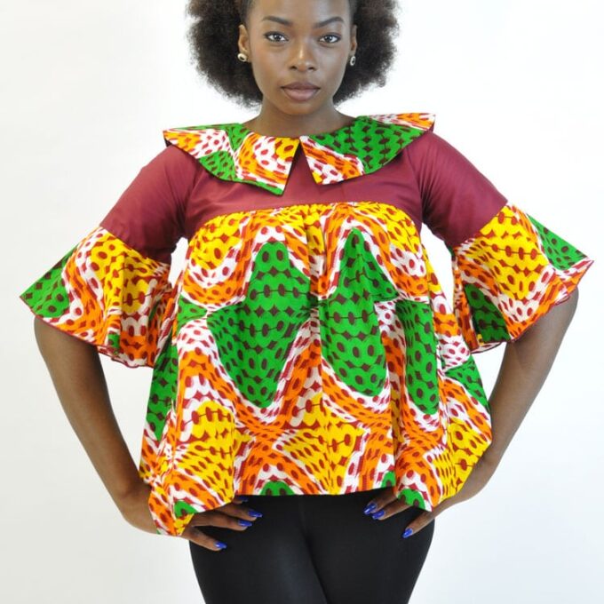 Frontal of model wearing a colourful South African inspired ladies peplum flared ruffle top in burgundy, orange, yellow and green.