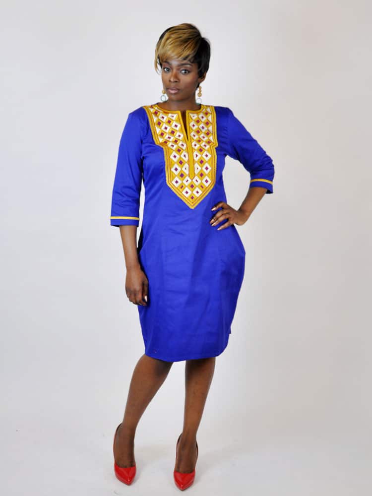Full frontal of model wearing a royal blue traditional African pencil dress with gold embroidery.