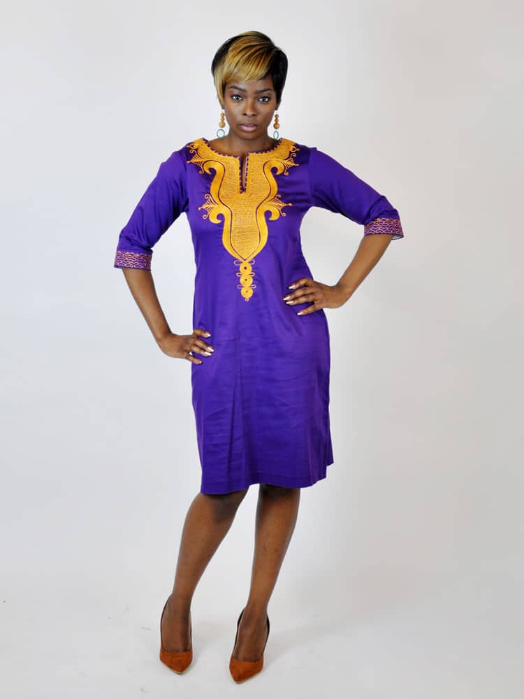 Frontal of model wearing a ladies traditional African indigo purple knee length pencil dress with gold embroidery on the front and sleeves.