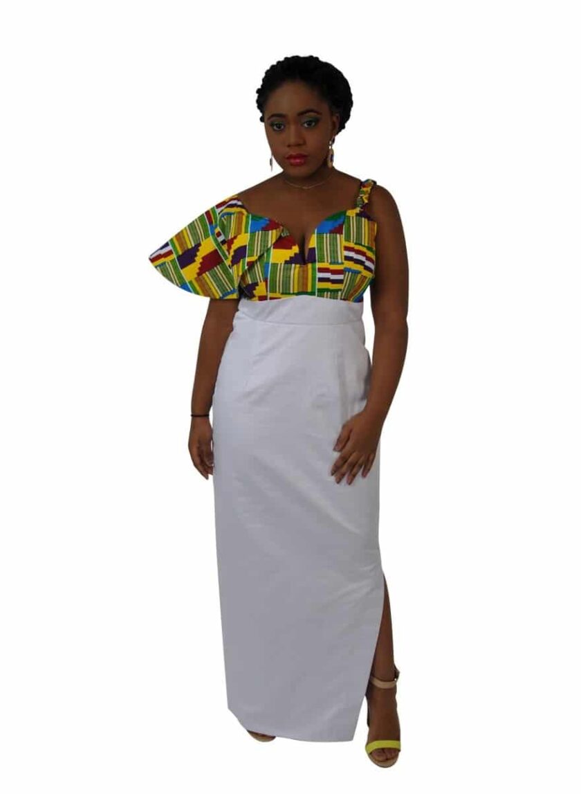 Frontal of model wearing a white African inspired asymmetrical fusion dress with Kente print detail on the bodice and right sleeve.