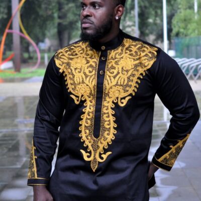 Close shot of model wearing our custom made black African suit with intricate gold embroidery which can be customised.