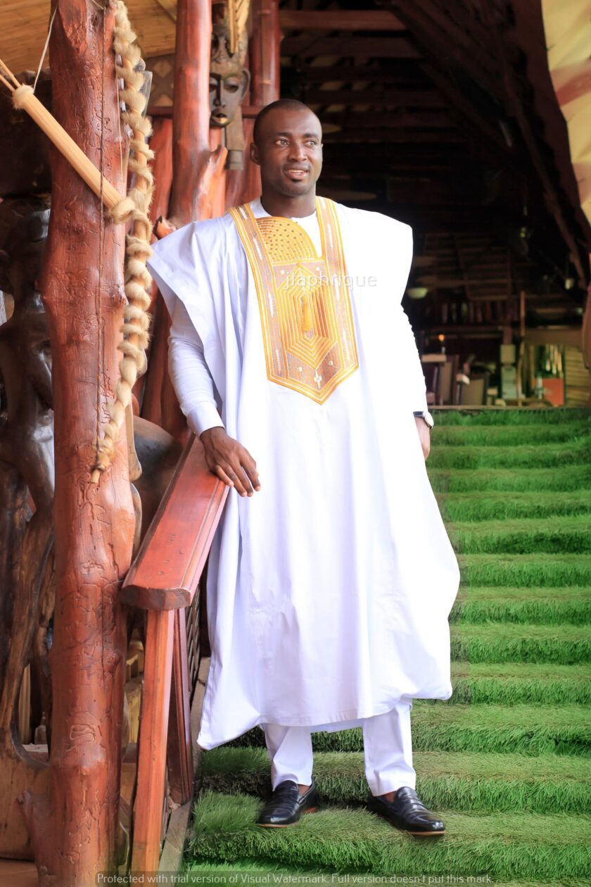 Frontal of male model wearing a traditional longline African suit with embroidery detail on the front. Perfect for a special occasion, wedding or Eid.
