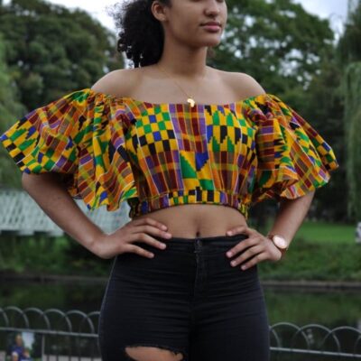 Full frontal of model wearing a colourful butterfly sleeve crop top in all over African print.