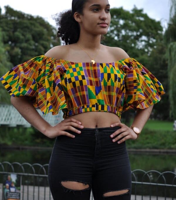 Full frontal of model wearing a colourful butterfly sleeve crop top in all over African print.