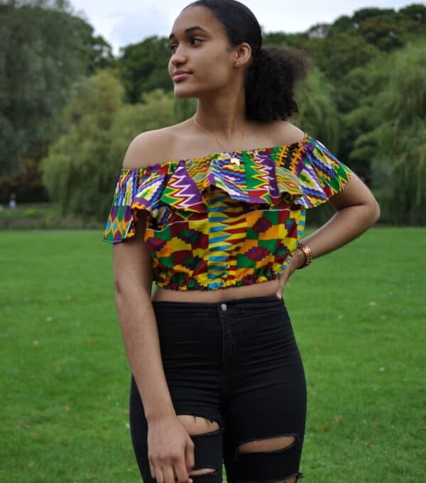 Full frontal of our model wearing an African frill crop top in all over colourful print. Features an off shoulder design and short sleeves.