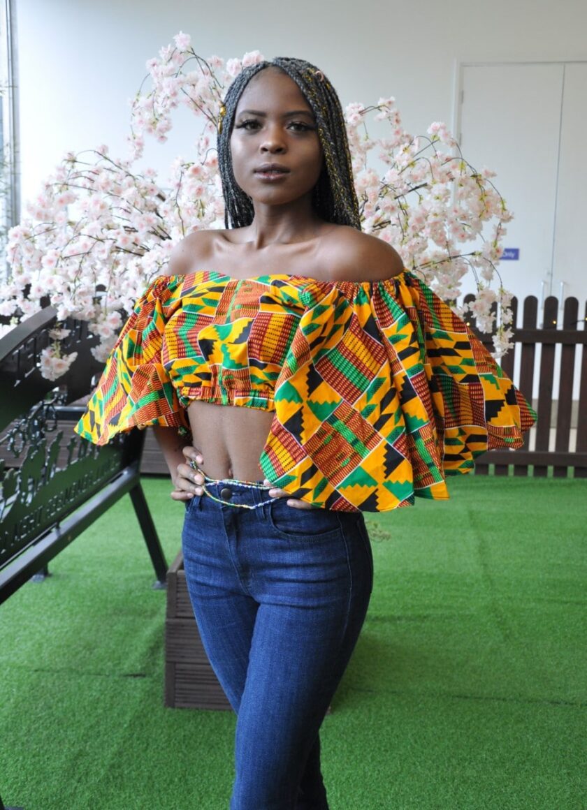 Side shot of another model wearing a colourful butterfly sleeve crop top in all over African print.
