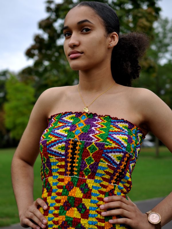 Close-up of model wearing a colourful tube top in all over African Kente print pattern.