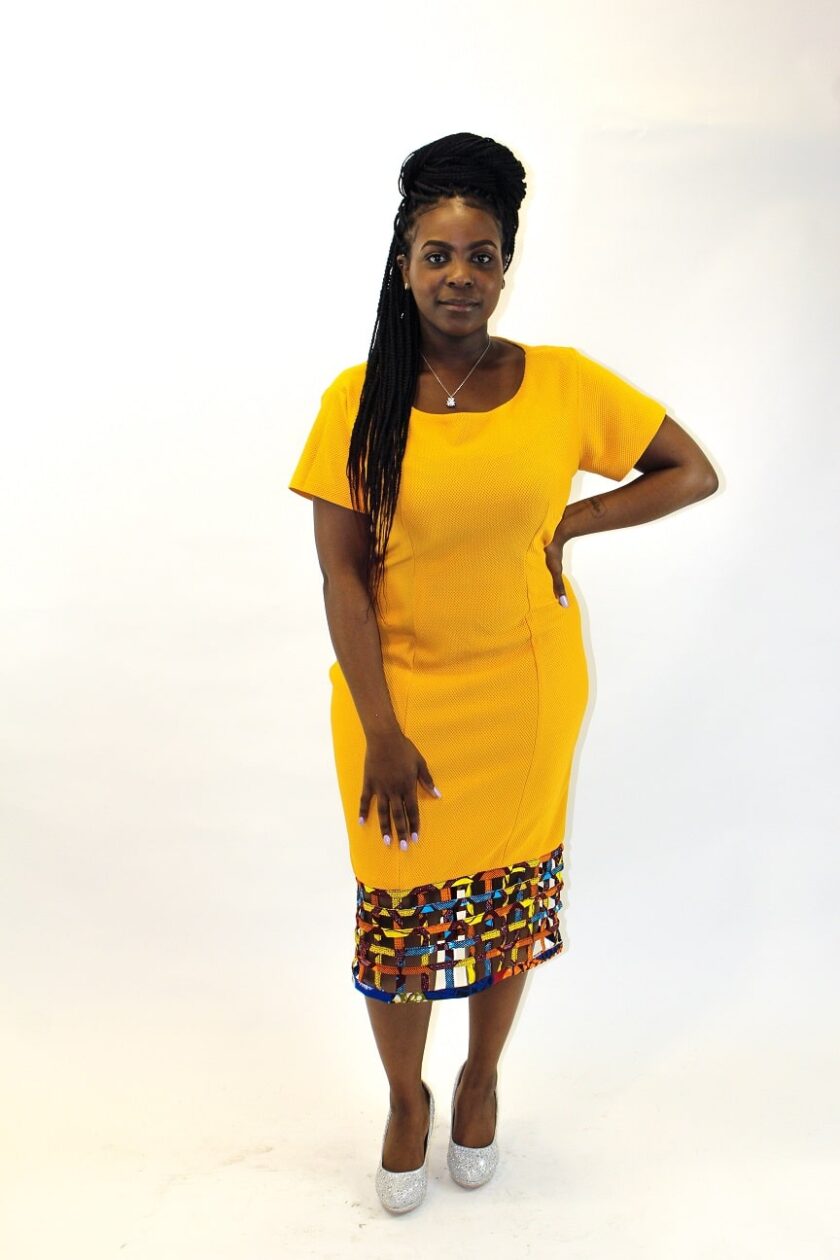 Frontal of model wearing a solid yellow bodycon dress with mesh detail on the hem.