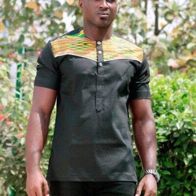 Close frontal of model wearing a solid black short sleeve shirt with vibrant multi-coloured Kente print across and above the chest to the neckline.
