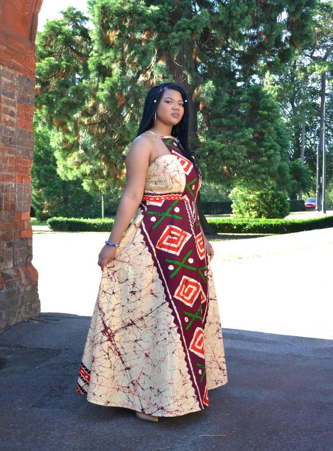 Frontal of model wearing a stunning halterneck maxi dress with mixed design in all over African Ankara print.