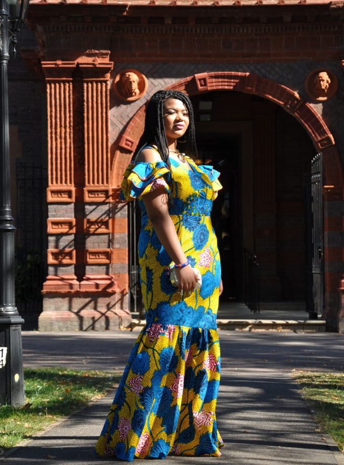 Frontal of model wearing a special occasion dress in all over floral African Ankara print pattern.