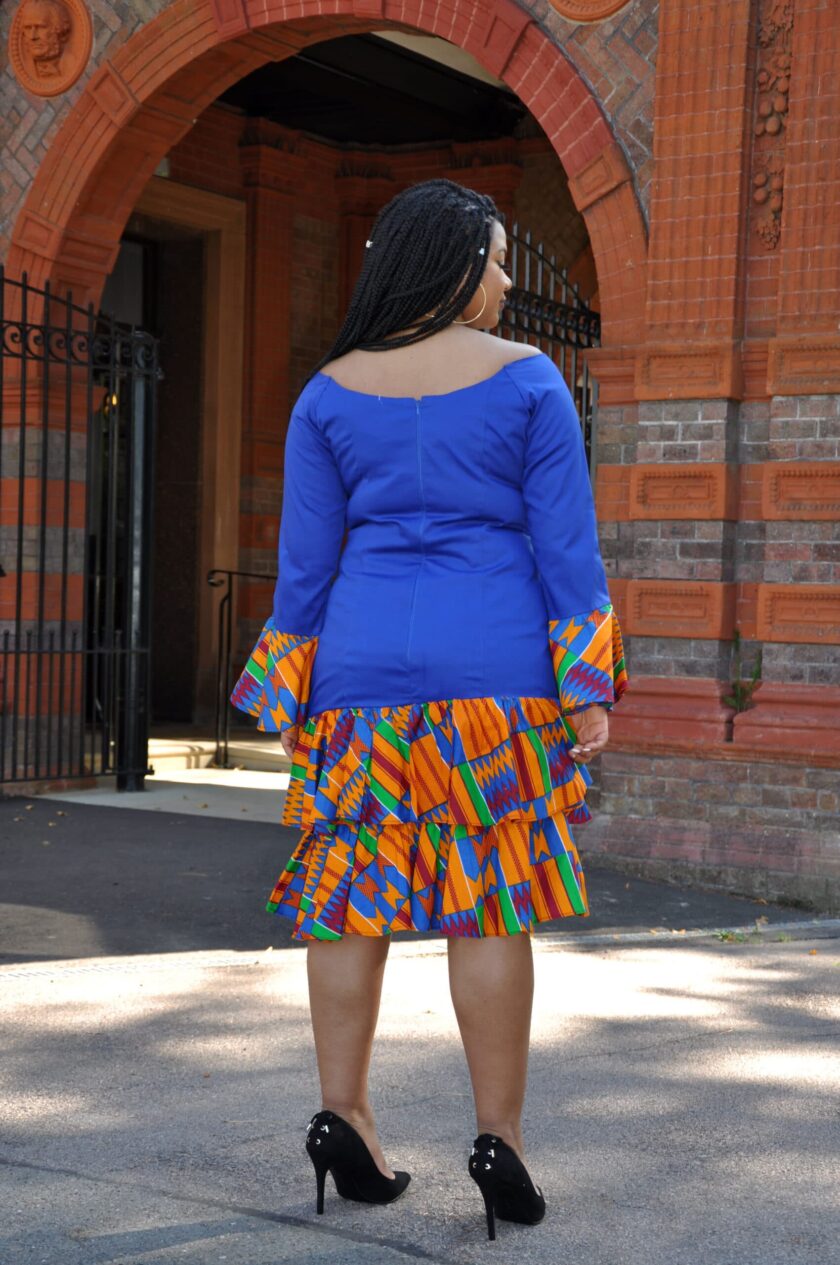 Back shot of model wearing a long sleeved blue bodycon dress with a layered ruffle hem in colourful African Kente print pattern.