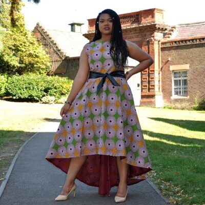 Frontal of model wearing a high low dress in all over African Ankara / Subra print pattern.