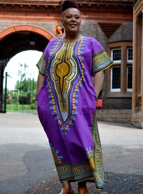 Full frontal of model wearing this dress in purple & multi-coloured print.
