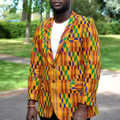 Frontal of model wearing a men's single breasted blazer in vibrant, colourful all over African Kente print pattern.