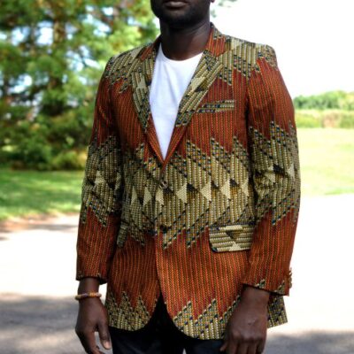 Frontal of model wearing a men's single breasted blazer in brown, green and cream, multi-coloured all over African Ankara print pattern.