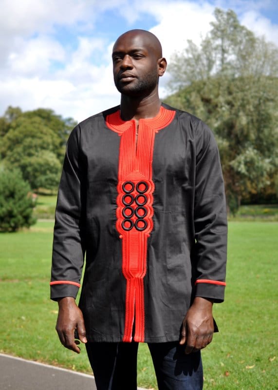 Frontal of model wearing our men's traditional African black shirt with red embroidery detail on the front and sleeves.
