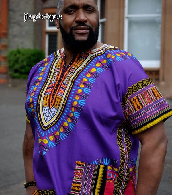 Close shot of model wearing a men's purple traditional African shirt with Angelina dashiki pattern.