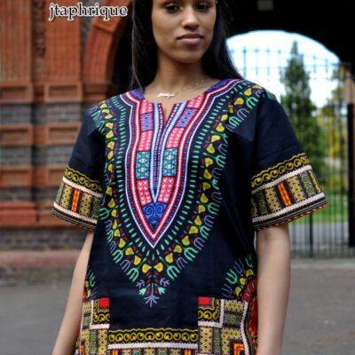 Close frontal of model wearing a ladies black traditional African Dashiki shirt with pink and multi-coloured Angelina print pattern on chest, sleeves and hem.