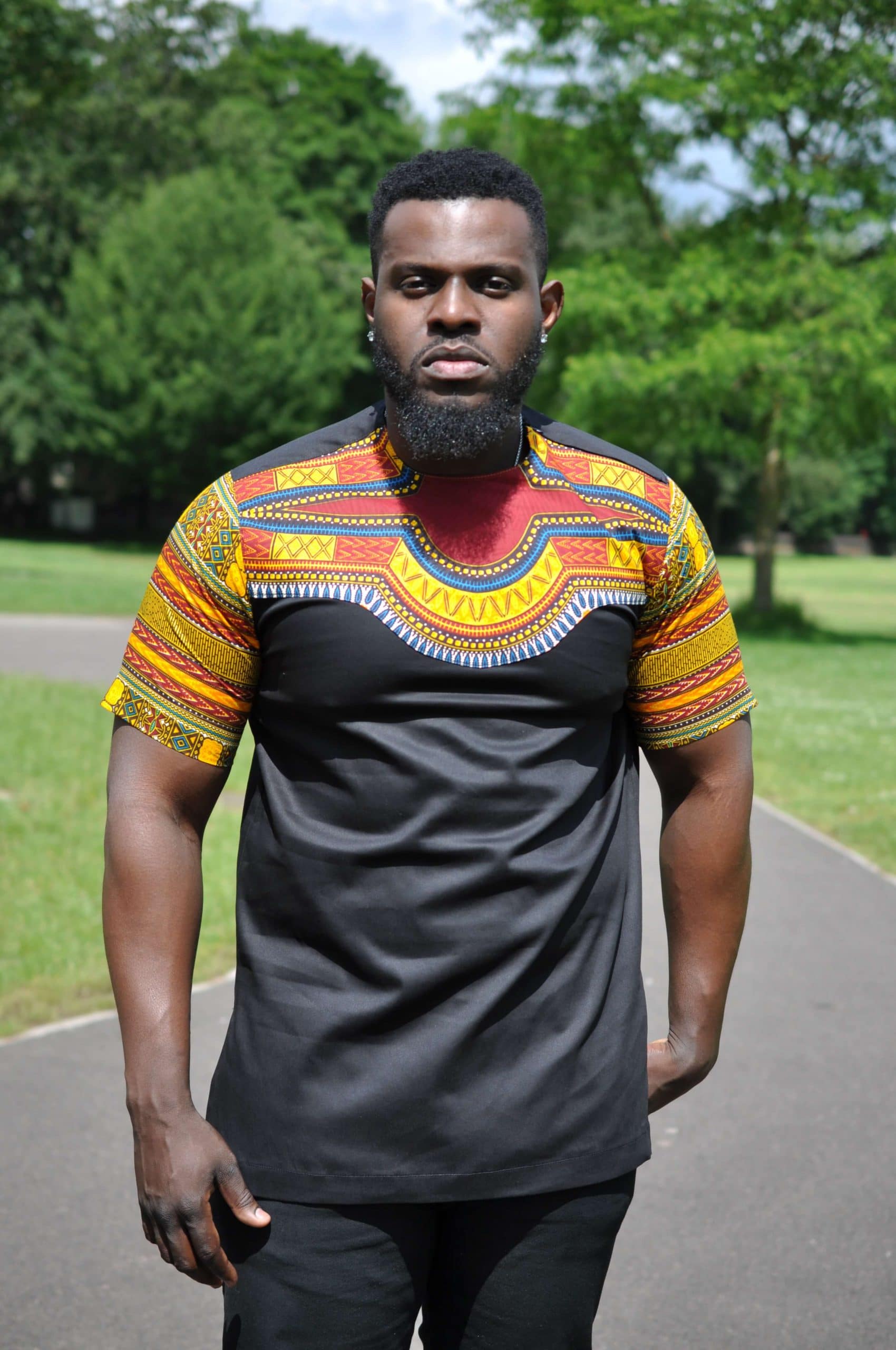 Close frontal of model wearing our Kwado African-inspired shirt designed with colourful Angelina Dashiki print pattern on the upper chest, neckline and sleeves.