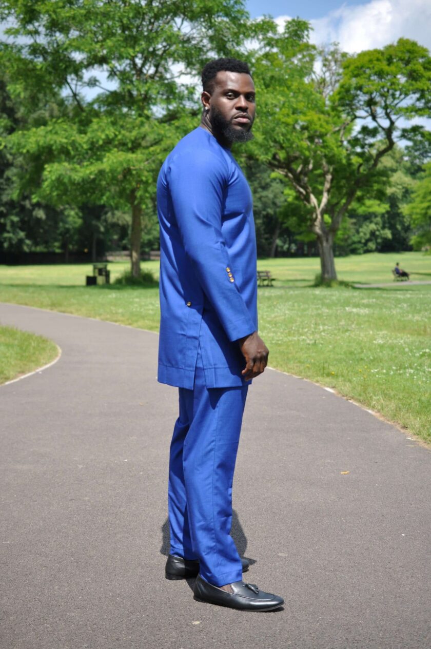 Side shot of model wearing a solid blue men's suit pants set made from suiting fabric.