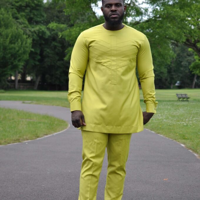 Full frontal of model wearing a custom made solid chartreuse yellow African men's suit with embroidery detail on chest in matching colour.