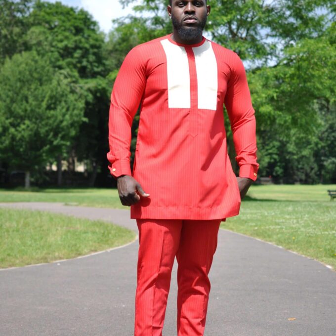 Full frontal of model wearing a custom made solid red men's African suit with two white vertical embroidery panels on the chest.