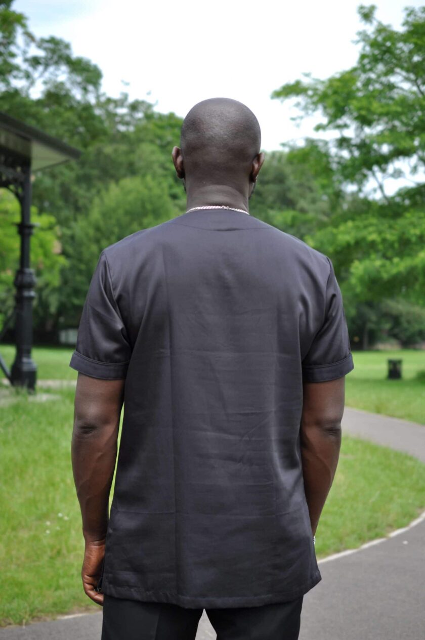 Back shot of model wearing a short sleeve African shirt in solid black.