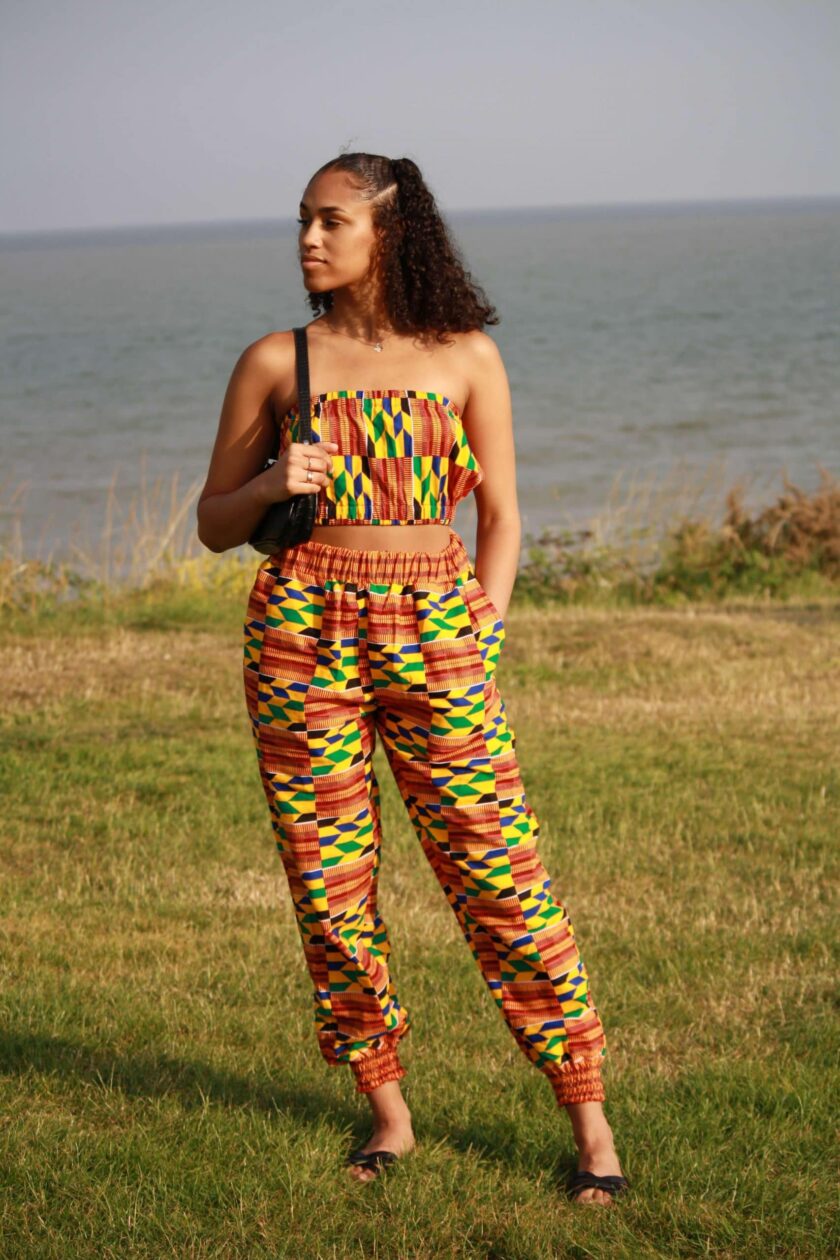 Full frontal of model wearing a bandeau crop top and matching joggers in colourful African print.