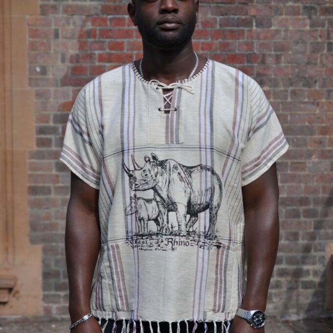 Frontal of model wearing a short sleeved beige boho shirt with African Rhino scene (adult and baby) on the front.