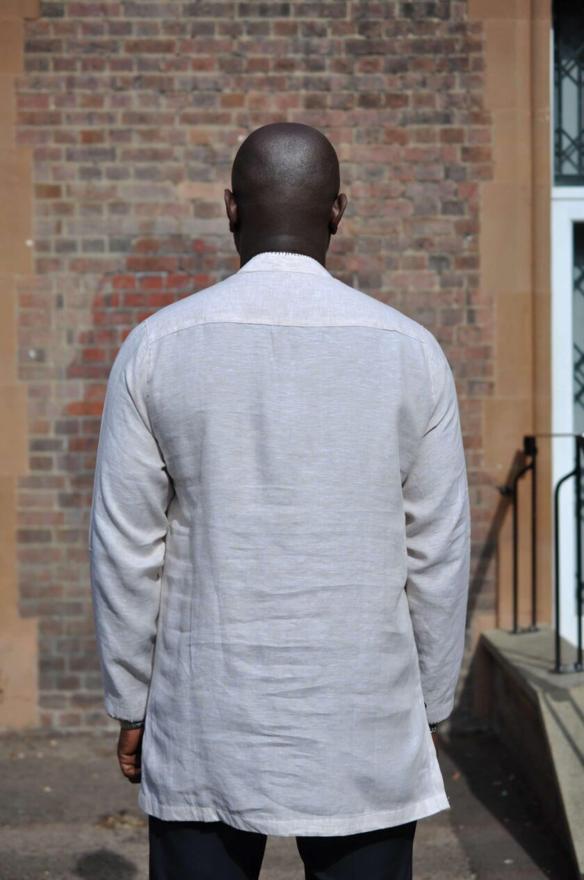 Back shot of model wearing a light grey men's long sleeve polo shirt made from linen.