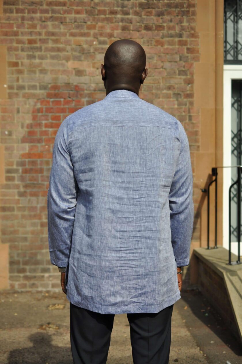 Back shot of model wearing a light grey men's long sleeve polo shirt made from linen.