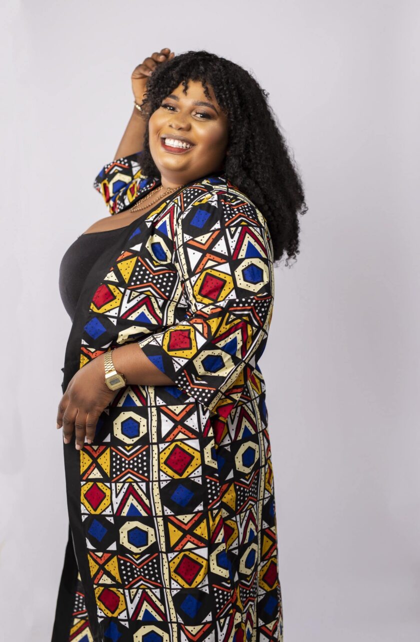 Close side shot of model wearing a fabulous plus size ladies kimono coat in all over vibrant African Ankara print.