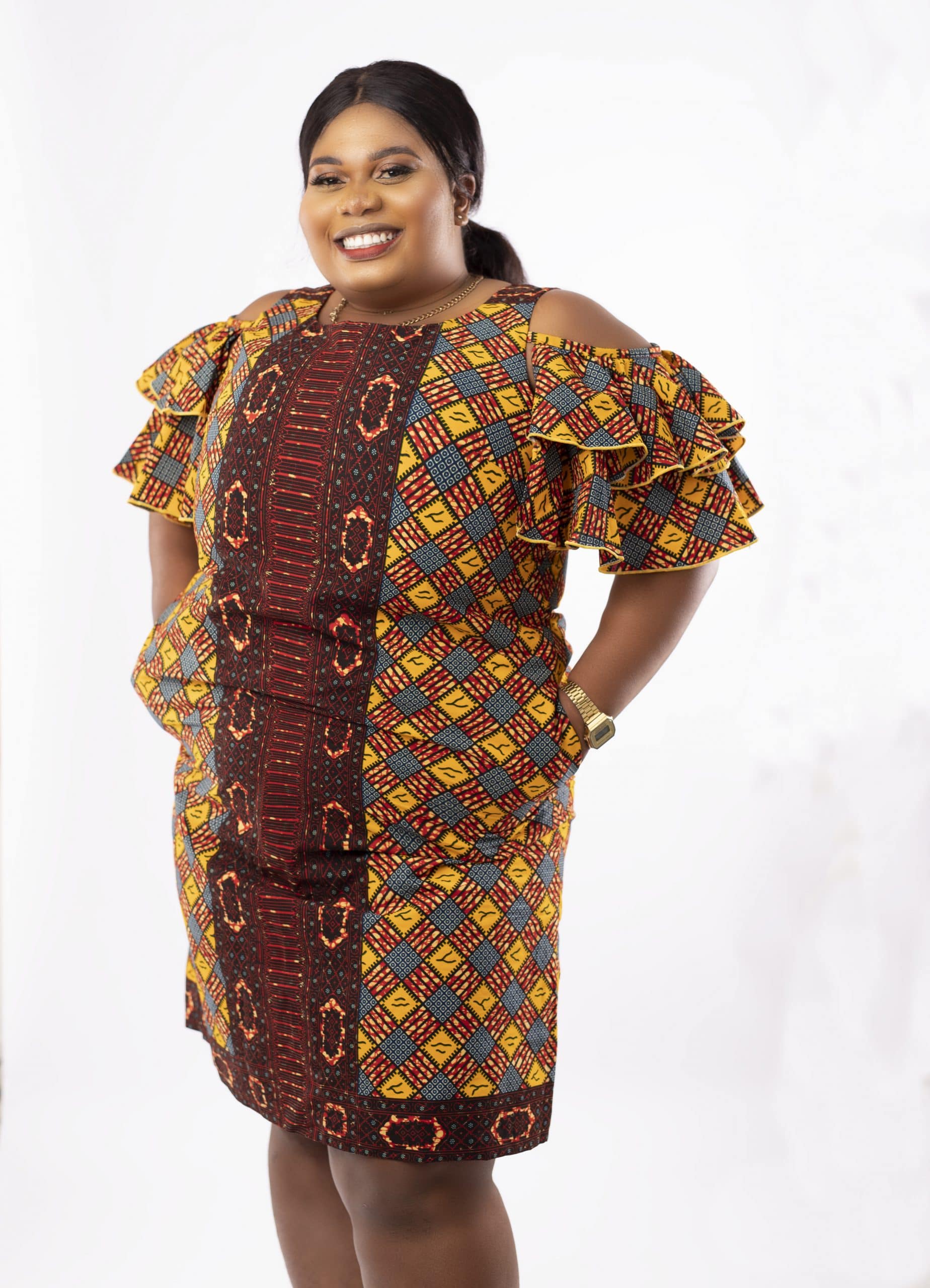 Frontal of model wearing a plus size cold shoulder frill dress in all over African print.