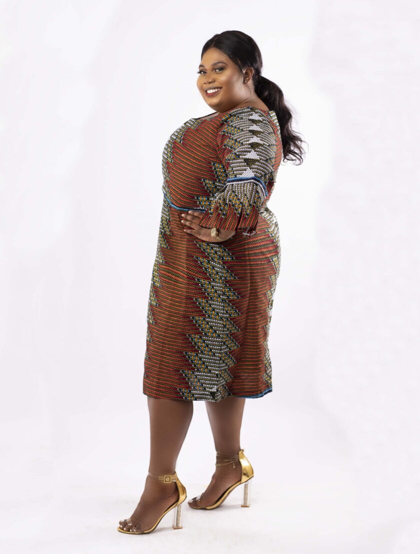 Frontal of model wearing a plus size midi dress in all over African print.