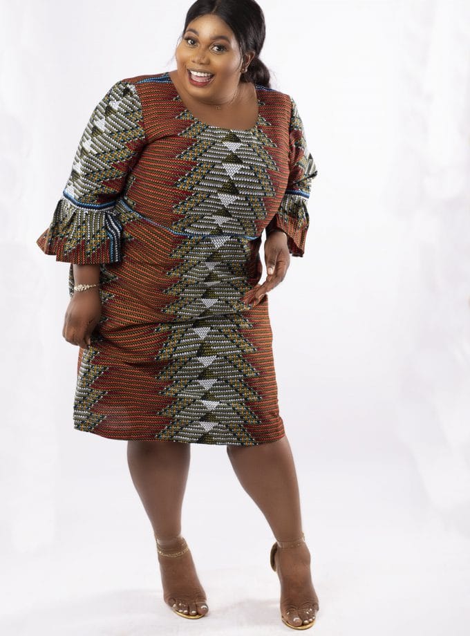 Frontal of model wearing a plus size midi dress in all over African print.