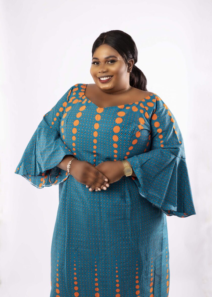Frontal of model wearing a plus size occasion dress in all over African Ankara print.