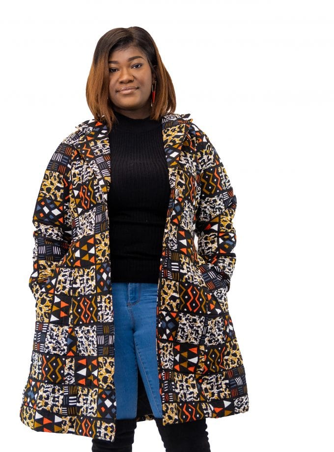 Full frontal of model wearing a medium length blue and orange multi-coloured African patchwork print coat.