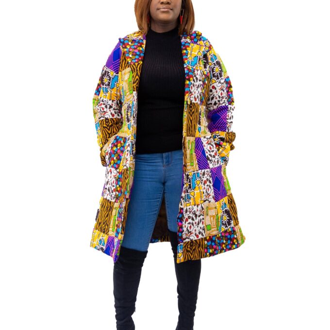 Full frontal of model wearing a medium length colourful African patchwork print coat.