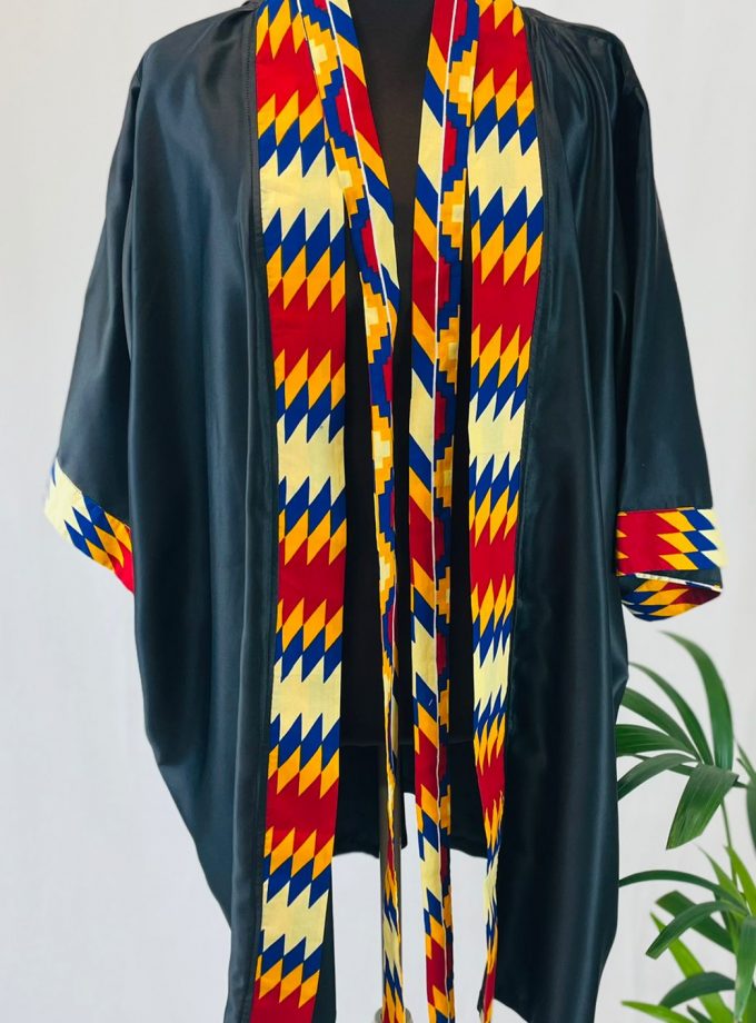 Front shot of a black satin robe with colourful African print on the sleeve cuffs, neckline and opening.