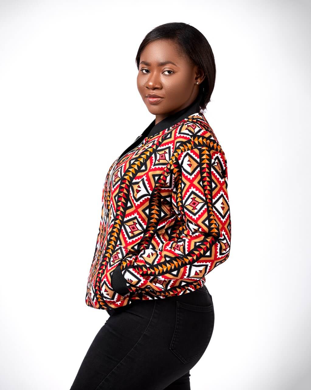 Side shot of model wearing a ladies bomber jacket in all over African print.