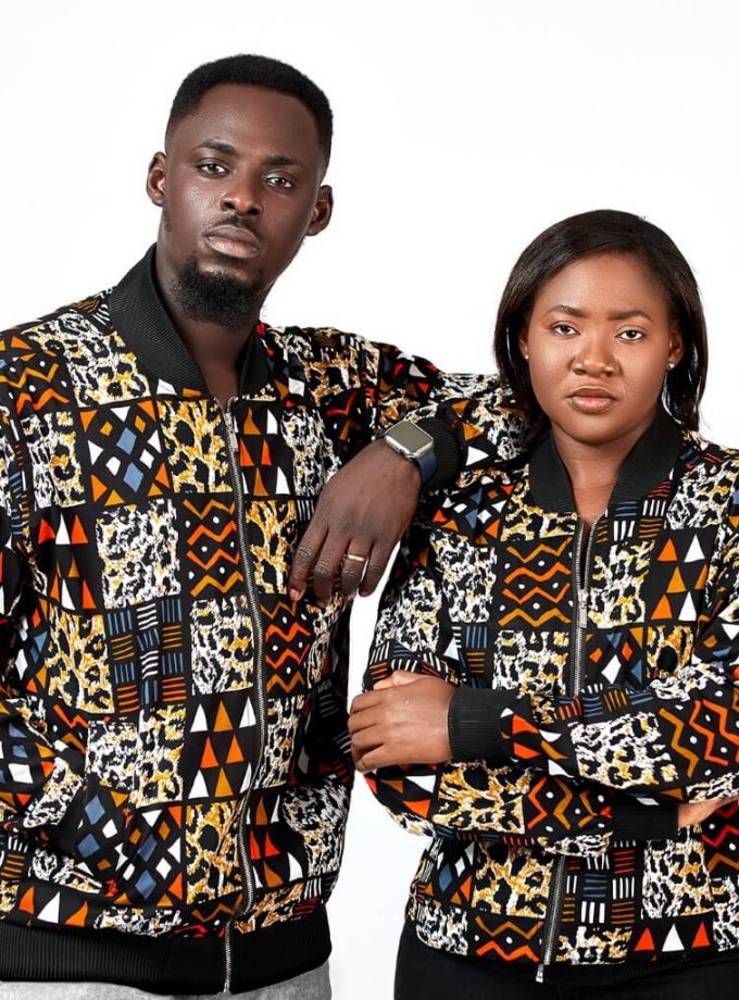 Frontal of models wearing unisex bomber jacket in African patchwork print, Kente style.