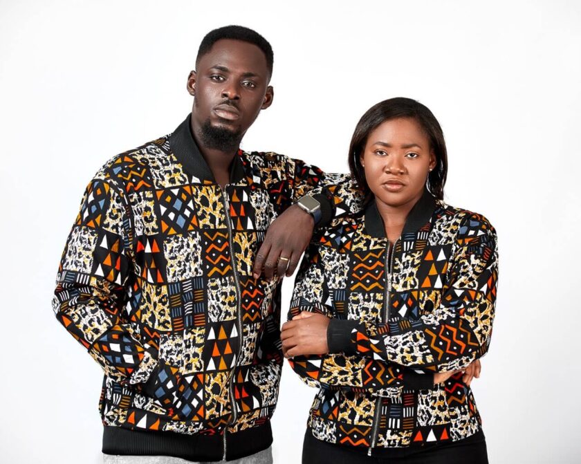 Frontal of models wearing unisex bomber jacket in African patchwork print, Kente style.