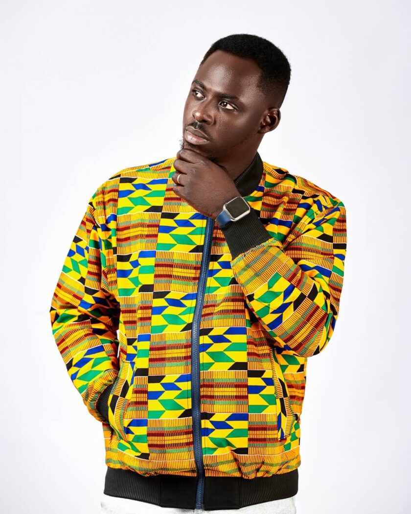 Frontal of model wearing our men's Deja Bomber Jacket in all over colourful / multi-coloured African Kente Print pattern.
