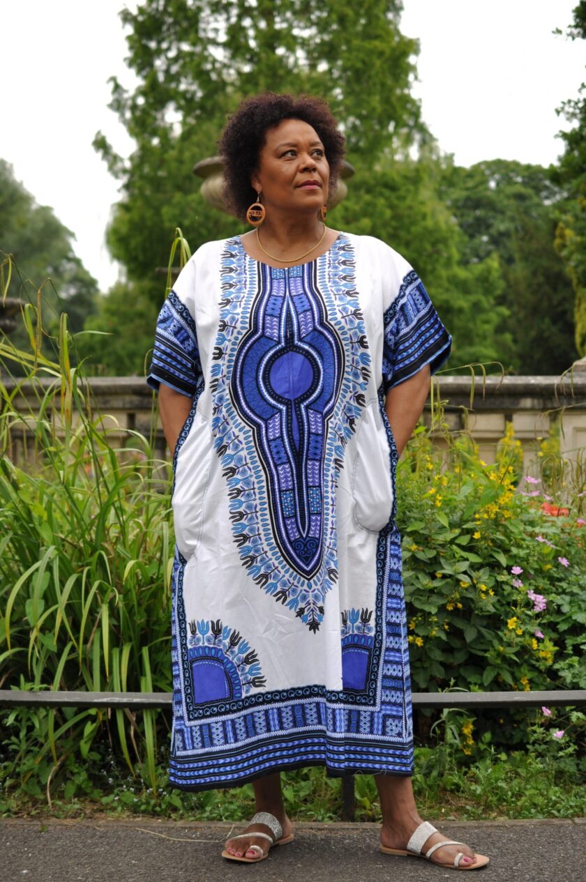 Frontal of model wearing our Dashiki Kaftan Zip Front Maxi Dress in white and blue. Features Angelina dashiki pattern.